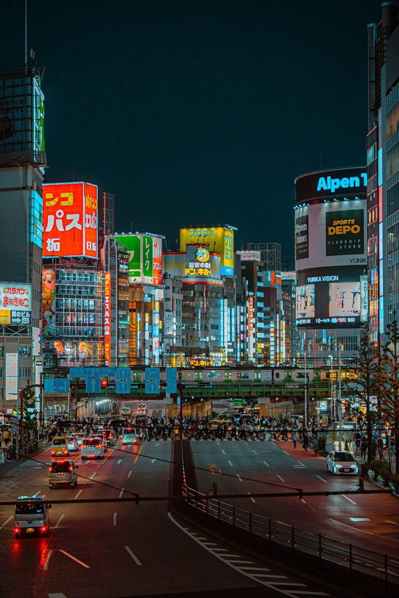A busy city street at night with neon lights