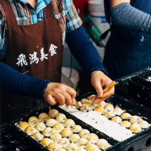 person in blue and red long sleeve shirt holding brown -Go Japan Now - Explore & Experience Japanwooden tray with cookies
