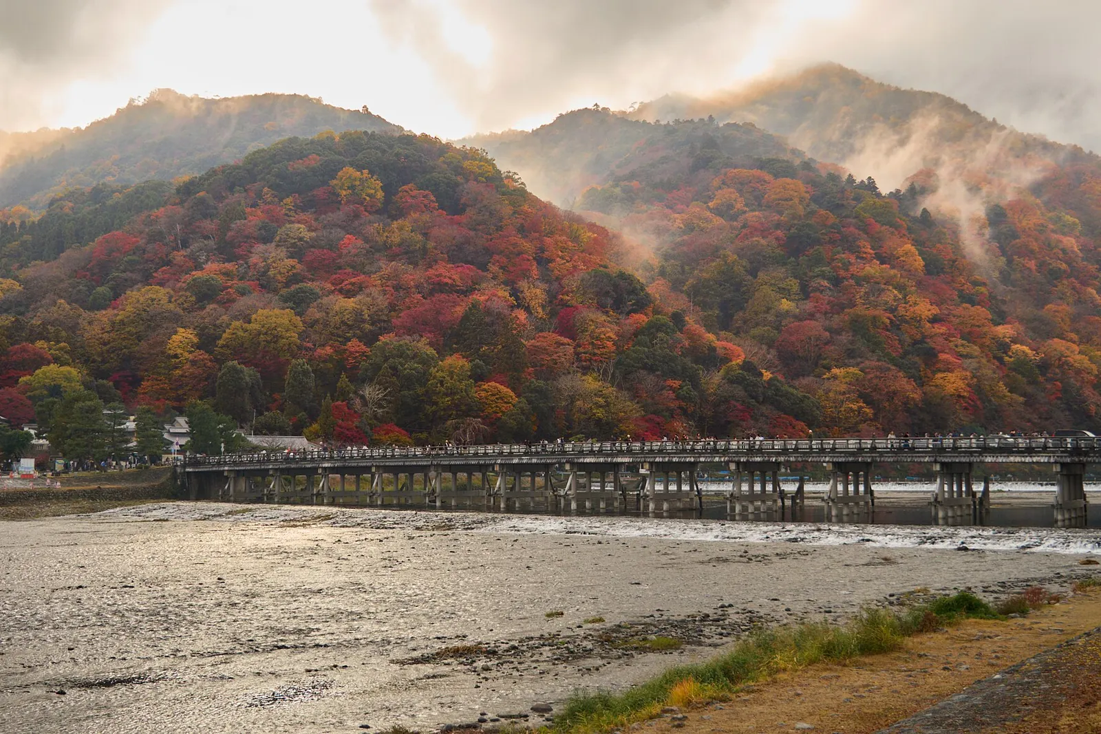 Togetsukyo Bridge in Kyoto, with the autumn-colored hills of Arashiyama in mist behind it